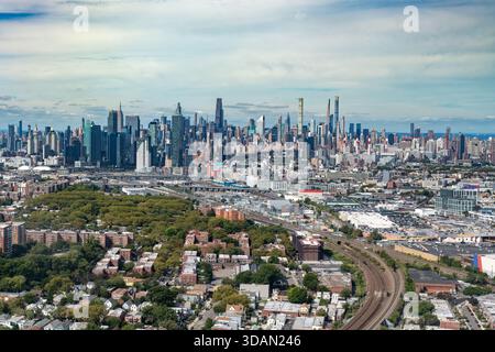 Ein gewaltiges Luftpanorama fängt die Weite von New York City ein, während die Wohnviertel in Richtung der dichten Skyline von Midtown Manhattan führen. Stockfoto