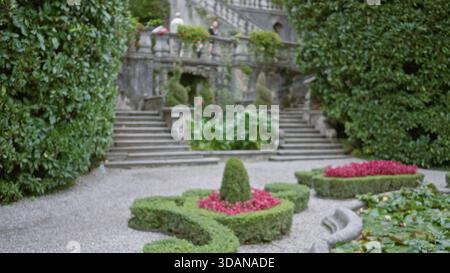 Formeller Garten mit abgeschnittenen Hecken, Kiesparterres und Steintreppen, sanft verschwommener Bokeh-Garten; Hintergrund-Copyspace-Vorlage Ruhe. Stockfoto