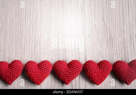 Valentinstag. Rote Strickherzen auf grauem Hintergrund. Flache Lagen Stockfoto