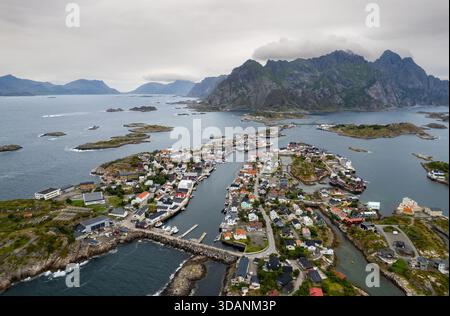 Drohnenansicht des Dorfes Henningsvaer über kleine Inseln mit Bergen im Hintergrund. Lofoten-Inseln Norwegen Stockfoto