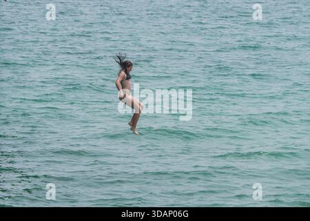 11. Dezember 2025 Ein Schwimmer taucht an einem heißen Sommertag von einem Pier in Adelaide Credit Amer Ghazzal/Alamy Live News Stockfoto