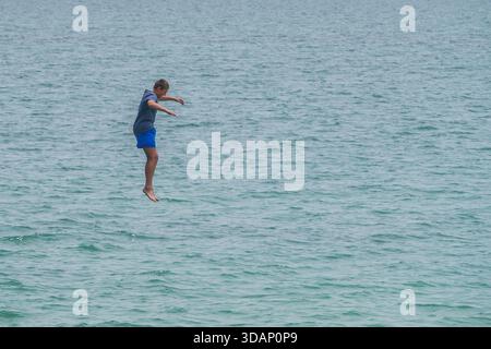 11. Dezember 2025 Ein Schwimmer taucht an einem heißen Sommertag von einem Pier in Adelaide Credit Amer Ghazzal/Alamy Live News Stockfoto