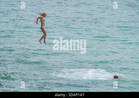 11. Dezember 2025 Ein Schwimmer taucht an einem heißen Sommertag von einem Pier in Adelaide Credit Amer Ghazzal/Alamy Live News Stockfoto