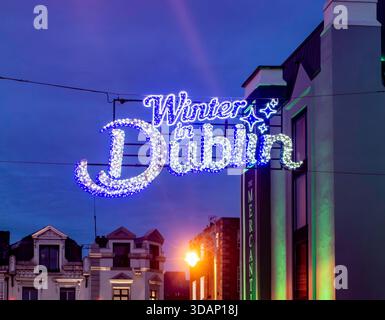 Das beleuchtete Schild „Winter in Dublin“ mit violetten und weißen Lichtern hängt über der George's Street, einem Teil der festlichen Ausstellung der Stadt. Stockfoto