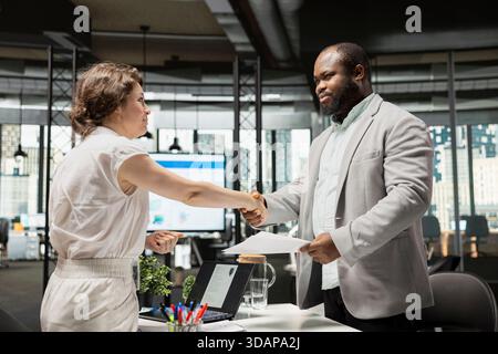 Handshake schließt das erfolgreiche Interview zwischen Recruiter und Jobsuchender ab und zeigt die Vereinbarung über die rechtlichen Bedingungen für das Arbeitsverhältnis und die Vorbereitung auf das Onboarding im Team. Karrierefortschritt. Stockfoto