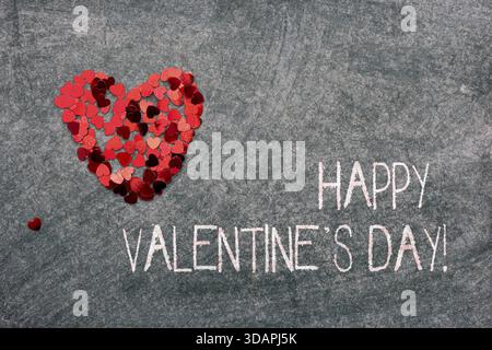 Glückwunsch zum Valentinstag: Konfetti-Herz auf der Tafel Stockfoto