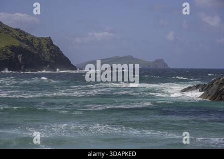 Wellen krachen gegen Klippen im Hintergrund Inishtooskert Island (Sleeping Giant), Clogher Strand, Dunurlin, Kerry, Irland Stockfoto