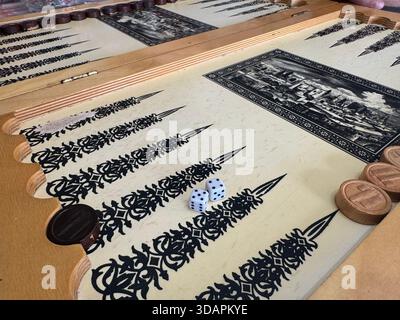 Blöcke auf hölzernem Hintergrund. Zugeschnittenes Bild von Backgammon, der auf einem Holzbrett über weißem Hintergrund spielt. Brett für ein Spiel Backgammon auf einem Stockfoto