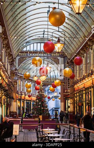 Weihnachtsdekorationen schmücken den Leadenhall Market in London, wo Shopper und Diners die festliche Atmosphäre genießen. Stockfoto