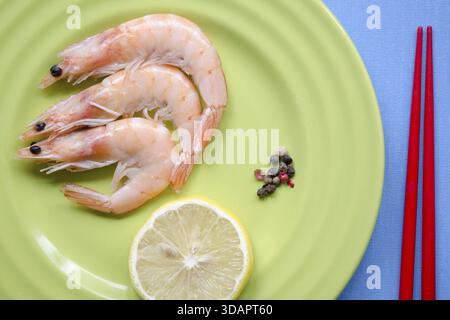 Shrimps-Portion auf grüner Platte mit Zitronenscheibe Stockfoto