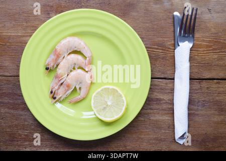 Shrimps-Portion auf grüner Platte mit Zitronenscheibe Stockfoto