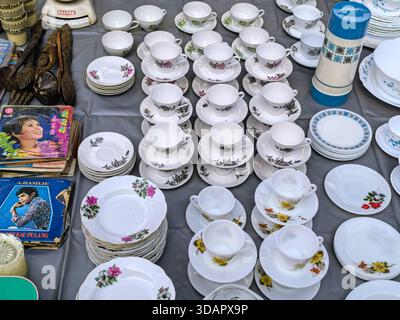 IPOH, MALAYSIA – 9. NOVEMBER 2025: Ein Blick von oben auf Stapel von alten Porzellanbechern, Untertassen und Tellern, die zum Verkauf angeboten werden. Stockfoto