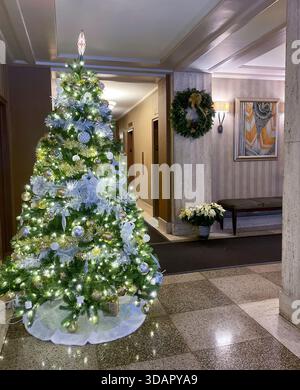 Hell erleuchteter Weihnachtsbaum in der Lobby eines gehobenen Koop-Gebäudes in Murray Hill, 2025, New York City, USA Stockfoto