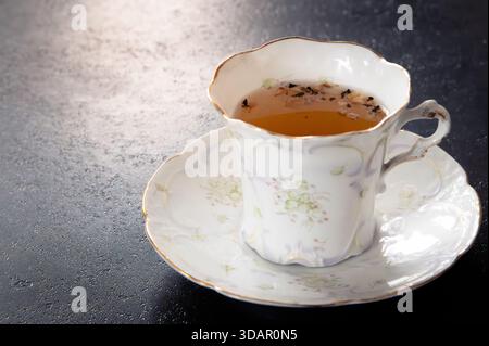 Teetasse und Untertasse auf dunklem Hintergrund, Kopierraum links Stockfoto