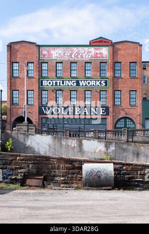 Altes Backsteingebäude in der Innenstadt von Lynchburg, Virginia, gemalt mit Schildern für Coca-Cola, Bottling Works, Wolfbane Stockfoto