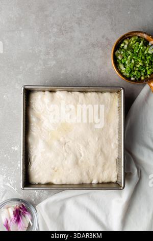 Draufsicht der Focaccia-Teigprüfung in der Backform, Draufsicht eines Focaccia-Brotteigs mit hoher Flüssigkeitszufuhr in einer Pfanne Stockfoto