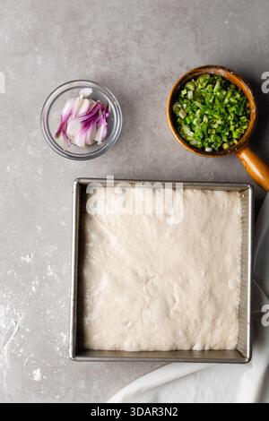Draufsicht der Focaccia-Teigprüfung in der Backform, Draufsicht eines Focaccia-Brotteigs mit hoher Flüssigkeitszufuhr in einer Pfanne Stockfoto