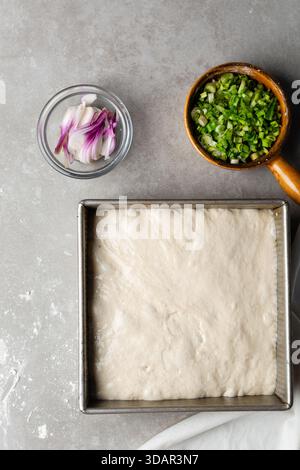 Draufsicht der Focaccia-Teigprüfung in der Backform, Draufsicht eines Focaccia-Brotteigs mit hoher Flüssigkeitszufuhr in einer Pfanne Stockfoto
