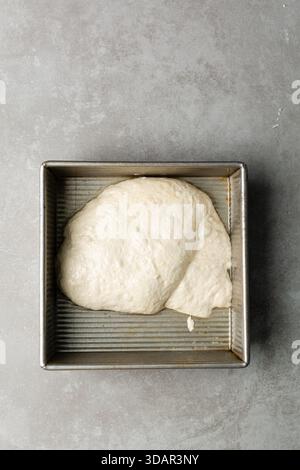 Draufsicht der Focaccia-Teigprüfung in der Backform, Draufsicht eines Focaccia-Brotteigs mit hoher Flüssigkeitszufuhr in einer Pfanne Stockfoto