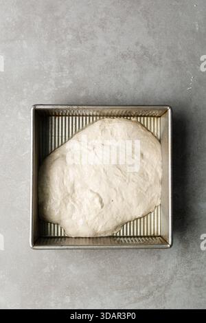 Draufsicht der Focaccia-Teigprüfung in der Backform, Draufsicht eines Focaccia-Brotteigs mit hoher Flüssigkeitszufuhr in einer Pfanne Stockfoto