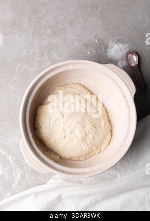 Draufsicht der Focaccia-Teigprüfung in einem Tontopf, Draufsicht auf einen Focaccia-Brotteig mit hoher Hydration in einem Donabe Stockfoto