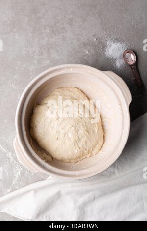 Draufsicht der Focaccia-Teigprüfung in einem Tontopf, Draufsicht auf einen Focaccia-Brotteig mit hoher Hydration in einem Donabe Stockfoto