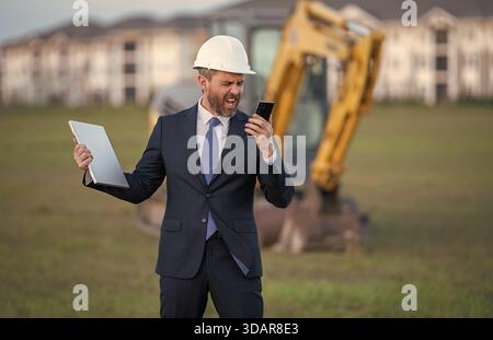 Buider-Mann in Anzug und Schutzhelm. Bauinvestor. Geschäftsmann-Investor vor der Baustelle. Erfolgreicher Investor. Ein hübscher Mann im Anzug Stockfoto