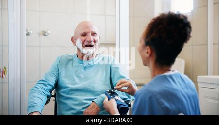 Seniorin, Krankenschwester und Rasieren im Badezimmer mit Rollstuhl, glücklich und sprechen mit der Pflege zu Hause. Menschen, Pflegepersonen und ältere Menschen mit Behinderung Stockfoto