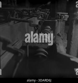Slawjansk, Ukrainische SSR, 1980er Jahre Eine Archivaufnahme eines automatisierten mechanischen Hubwerks im Armature-Isolator Plant (AIZ). Die komplexe Anordnung von Hebeln und Stangen, die von einem Elektromotor angetrieben werden, dient als Transfermechanismus für keramische Isolatorkomponenten an der Produktionslinie. Rechts ist ein Stapel weißer Keramikrohlinge zu sehen. Diese detaillierte Aufnahme zeigt die Maschinenbau- und Automatisierungsarbeiten in der friedlichen Donbass-Region. Stockfoto