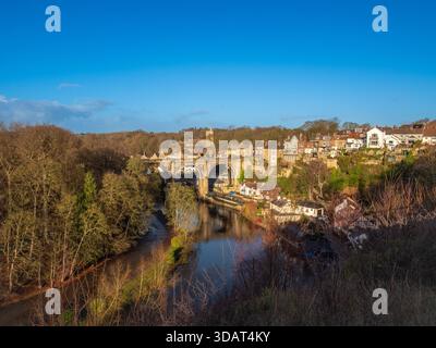 Die Steinbögen des Knaresborough Viaduct überqueren den Fluss Nidd, umgeben von Herbstbäumen. Stockfoto