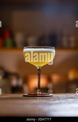 Eleganter Cocktail mit Zitrusschaum auf einer Holztheke Stockfoto