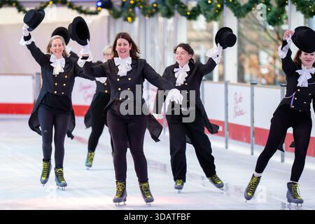 Anlässlich des World Ice Skating Day am 14. Dezember stellen Mitarbeiter der National Galleries of Scotland Schlittschuhlaufen eines der berühmtesten Gemälde aus Schottlands Sammlung nach, Sir Henry Raeburns Skating Minister. Zusammen mit Edinburghs Weihnachten gingen die Eislaufminister auf die Eislaufbahn in der George Street, um das Gemälde nachzuahmen. Das um 1795 gemalte Kunstwerk trägt den Namen Reverend Robert Walker Skating am Duddingston Loch, wurde aber liebevoll als Skating Minister bezeichnet. Bilddatum: Dienstag, 9. Dezember 2025. Stockfoto