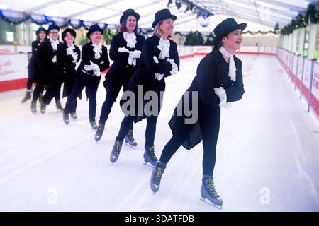 Anlässlich des World Ice Skating Day am 14. Dezember stellen Mitarbeiter der National Galleries of Scotland Schlittschuhlaufen eines der berühmtesten Gemälde aus Schottlands Sammlung nach, Sir Henry Raeburns Skating Minister. Zusammen mit Edinburghs Weihnachten gingen die Eislaufminister auf die Eislaufbahn in der George Street, um das Gemälde nachzuahmen. Das um 1795 gemalte Kunstwerk trägt den Namen Reverend Robert Walker Skating am Duddingston Loch, wurde aber liebevoll als Skating Minister bezeichnet. Bilddatum: Dienstag, 9. Dezember 2025. Stockfoto