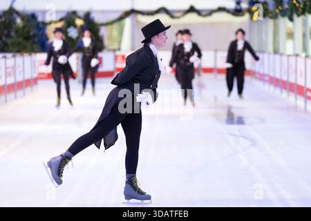 Anlässlich des World Ice Skating Day am 14. Dezember stellen Mitarbeiter der National Galleries of Scotland Schlittschuhlaufen eines der berühmtesten Gemälde aus Schottlands Sammlung nach, Sir Henry Raeburns Skating Minister. Zusammen mit Edinburghs Weihnachten gingen die Eislaufminister auf die Eislaufbahn in der George Street, um das Gemälde nachzuahmen. Das um 1795 gemalte Kunstwerk trägt den Namen Reverend Robert Walker Skating am Duddingston Loch, wurde aber liebevoll als Skating Minister bezeichnet. Bilddatum: Dienstag, 9. Dezember 2025. Stockfoto