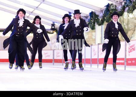 Anlässlich des World Ice Skating Day am 14. Dezember stellen Mitarbeiter der National Galleries of Scotland Schlittschuhlaufen eines der berühmtesten Gemälde aus Schottlands Sammlung nach, Sir Henry Raeburns Skating Minister. Zusammen mit Edinburghs Weihnachten gingen die Eislaufminister auf die Eislaufbahn in der George Street, um das Gemälde nachzuahmen. Das um 1795 gemalte Kunstwerk trägt den Namen Reverend Robert Walker Skating am Duddingston Loch, wurde aber liebevoll als Skating Minister bezeichnet. Bilddatum: Dienstag, 9. Dezember 2025. Stockfoto