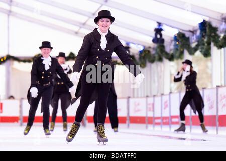 Anlässlich des World Ice Skating Day am 14. Dezember stellen Mitarbeiter der National Galleries of Scotland Schlittschuhlaufen eines der berühmtesten Gemälde aus Schottlands Sammlung nach, Sir Henry Raeburns Skating Minister. Zusammen mit Edinburghs Weihnachten gingen die Eislaufminister auf die Eislaufbahn in der George Street, um das Gemälde nachzuahmen. Das um 1795 gemalte Kunstwerk trägt den Namen Reverend Robert Walker Skating am Duddingston Loch, wurde aber liebevoll als Skating Minister bezeichnet. Bilddatum: Dienstag, 9. Dezember 2025. Stockfoto