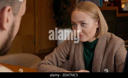 Junge Frau lächelt und redet, aktiv an einer Diskussion beteiligt Stockfoto