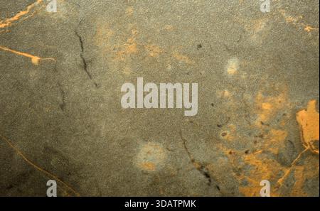 Schmutziger brauner Marmor mit orangen Adern, Nahaufnahme der polierten Oberfläche des Natursteins. Hintergrund, nahtlos, Textur. Stockfoto