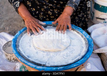 Nahaufnahme von beduin Frau, die palästinensische Pizza mit Mehl im Freien in Palestien-Landschaft kocht, traditionelles Essen Stockfoto