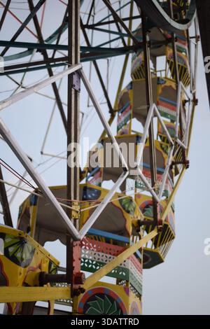 Nahaufnahme des mehrfarbigen Riesenrads während Dussehra Mela in Delhi, Indien. Unteransicht des Riesenradschwenkens. Riesenrad mit farbenfrohen Kabinen durin Stockfoto