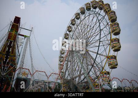 Nahaufnahme des mehrfarbigen Riesenrads während Dussehra Mela in Delhi, Indien. Unteransicht des Riesenradschwenkens. Riesenrad mit farbenfrohen Kabinen durin Stockfoto
