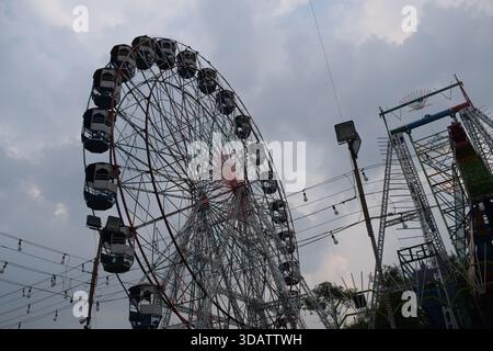 Nahaufnahme des mehrfarbigen Riesenrads während Dussehra Mela in Delhi, Indien. Unteransicht des Riesenradschwenkens. Riesenrad mit farbenfrohen Kabinen durin Stockfoto