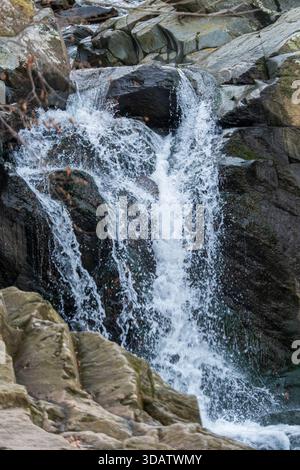 Blick auf das kaskadierende Wasser, das kraftvoll über dunkle Felsen fließt und ein faszinierendes Spektakel im Scott's Run Nature Preserve, Scott's Run, Virginia, UN, schafft Stockfoto