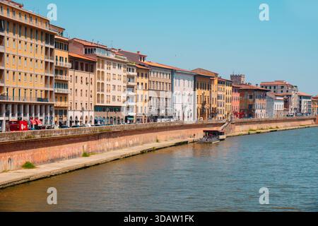 Pisa, Italien - 26. Juni 2025: Der Fluss Arno fließt durch Pisa neben den farbenfrohen Fassaden des Lungarno Mediceo im Stadtteil San Francesco, mit Stockfoto