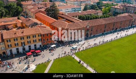 Pisa, Italien - 26. Juni 2025: Von der Spitze des Schiefen Turms aus betrachtet, entfaltet sich die Piazza dei Miracoli als urbane Szene mit Gehwegen, mittelalterlichen Gebäuden und Gebäuden Stockfoto