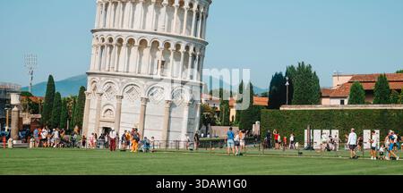 Pisa, Italien - 26. Juni 2025: Die unteren Ebenen des Schiefen Turms dominieren den Rahmen, während die Besucher entlang der umzäunten Pfade zirkulieren und lin bilden Stockfoto