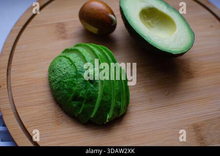 Avocado auf einem Holzbrett. Halbe Avocado. In Scheiben Geschnitten. Reif, saftig Stockfoto