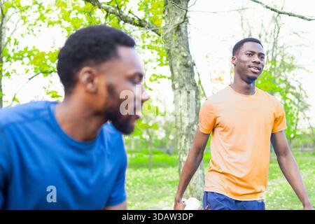 Afroamerikaner lächelt, während er sich draußen im Frühlingsmorgen ausdehnt. Stockfoto
