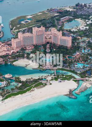 Majestätisch erhebt sich der Blick aus der Vogelperspektive auf das Grand Hotel, dessen pinkfarbene Fassade im Kontrast zum türkisfarbenen Meer und dem weißen Sandstrand, Great Harbour Cay, Berr, steht Stockfoto