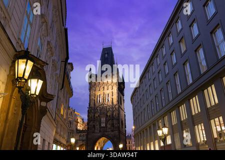 Abendlicher Blick auf den berühmten Pulverturm in Prag mit gotischer Architektur inmitten von sanft beleuchteten Straßen. Ein atemberaubendes Reiseziel in Tschechien Stockfoto